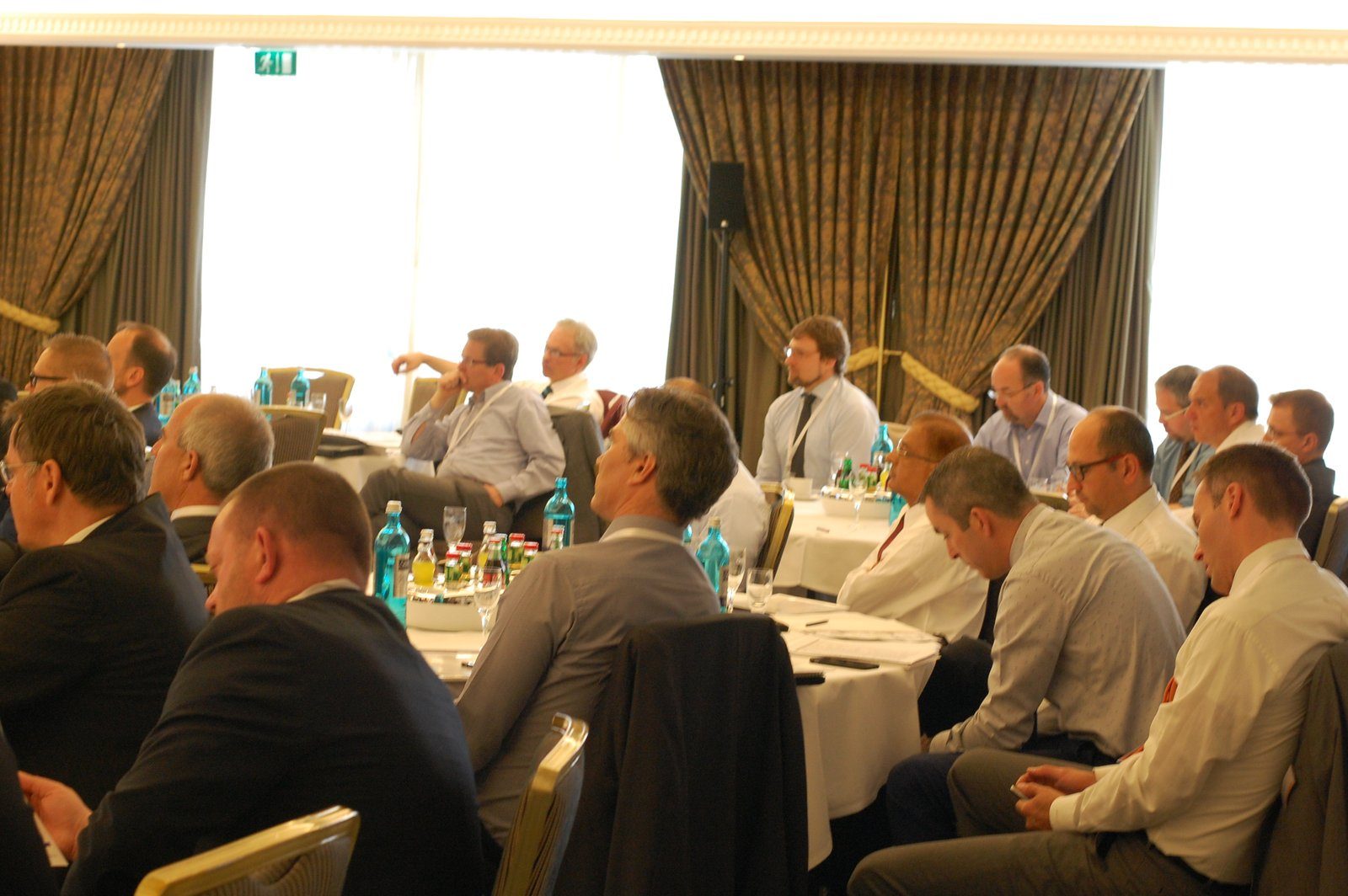 A seated audience at round tables during a previous Zenith Group event